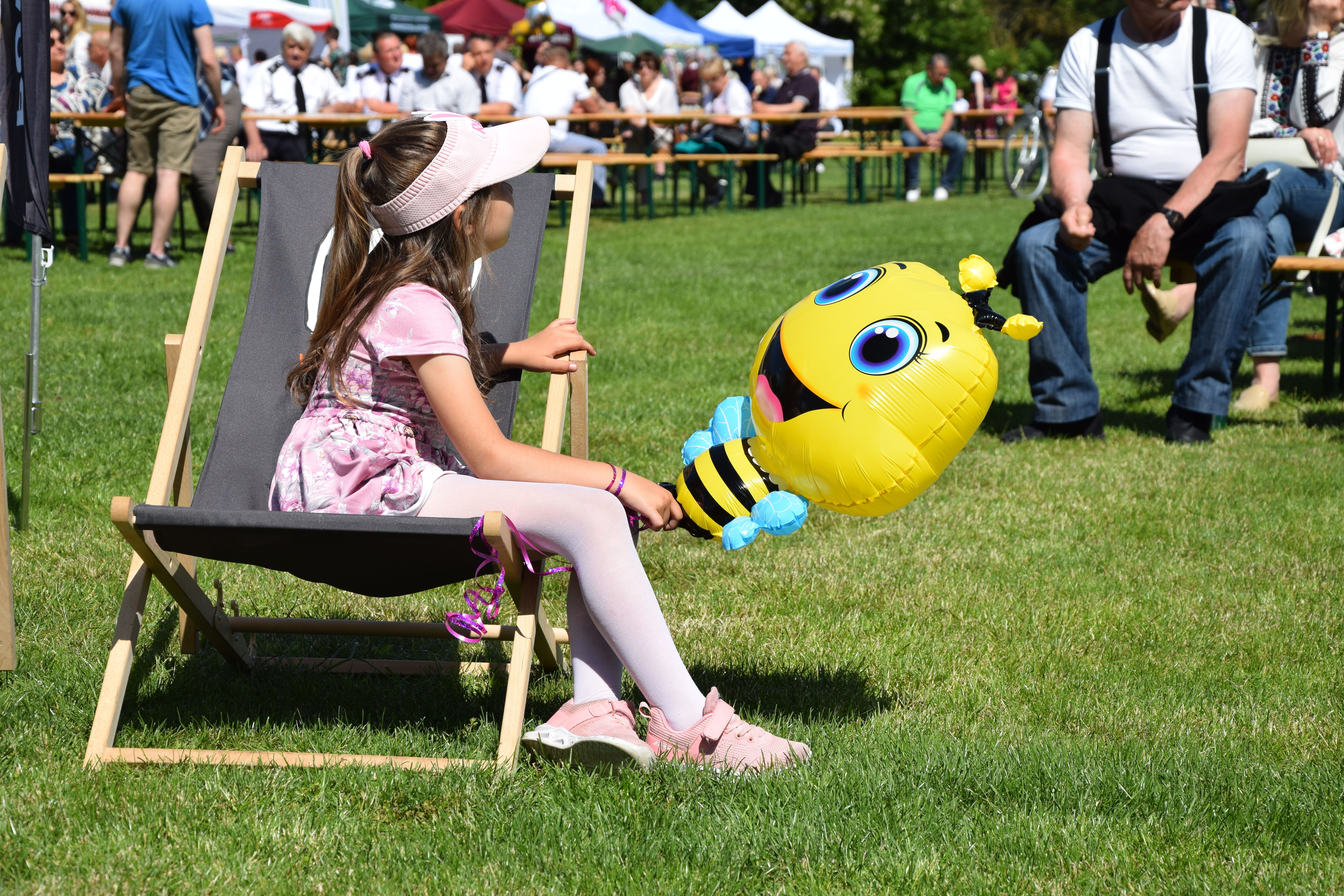 dziewczynka na leżaku z balonem w kształcie pszczółki