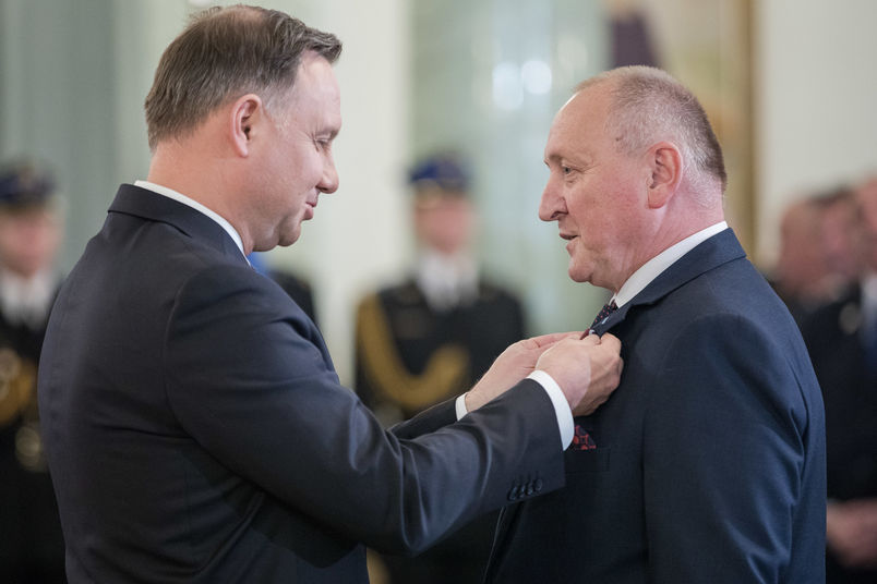 Prezydent RP przypina medal dyrektorowi Szabelskiemu