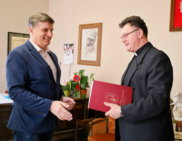 Burmistrz Leszek Michalak wręcza promesę na ręce proboszcza parafii w Bukowie ks. Mariusza Walasa