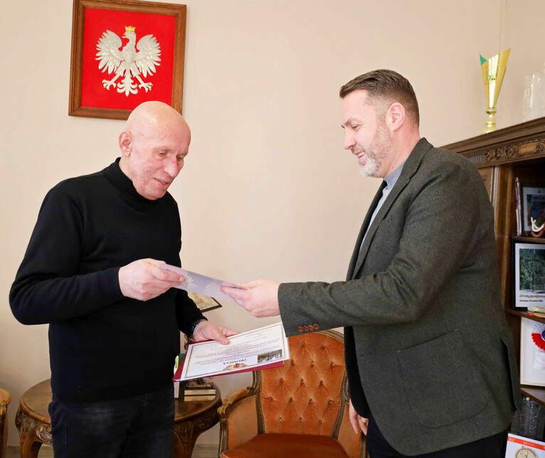 Zastępca burmistrza Przemysław Sikora wręcza promesę ks. Ryszardowi Menclowi